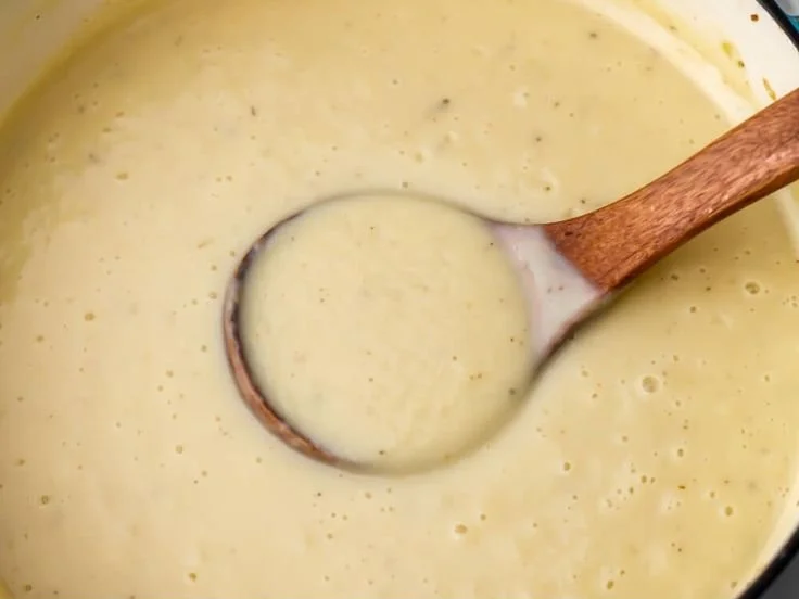 A bowl of creamy cauliflower potato leek soup garnished with fresh herbs