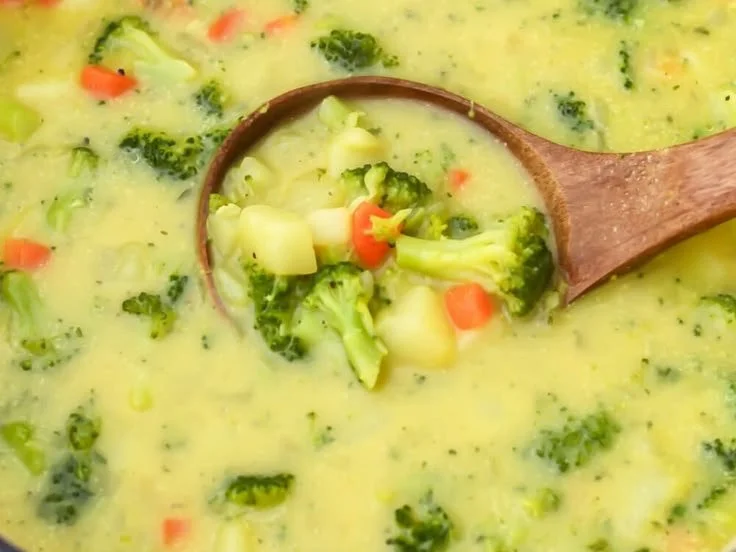 Creamy vegan broccoli and potato soup in a bowl garnished with herbs