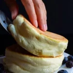 Fluffy Japanese souffle pancakes topped with syrup and berries