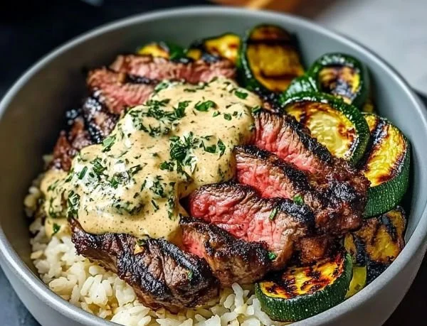 Delicious grilled steak bowl with sauce and grilled zucchini on a rustic table