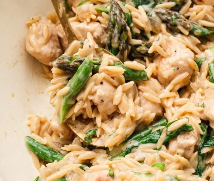 High-protein chicken orzo dish with colorful vegetables and herbs