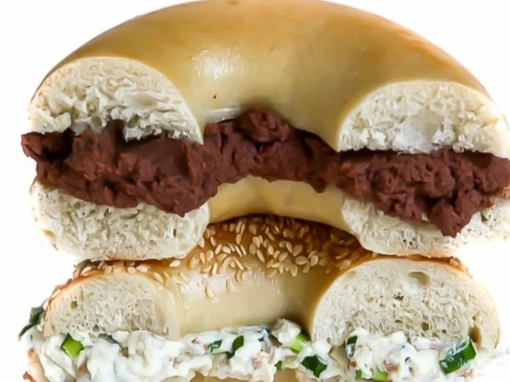 Homemade vegan cream cheese spread on a bagel with fresh herbs