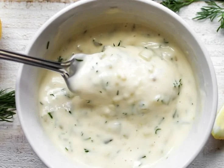 Bowl of homemade vegan tartar sauce with fresh herbs and lemon