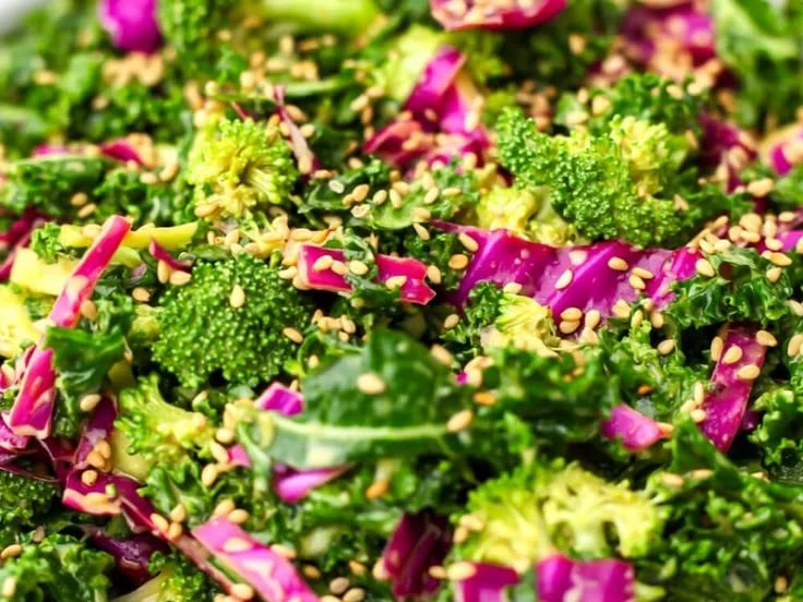 Kale Salad topped with Nutritional Yeast Dressing in a vibrant bowl