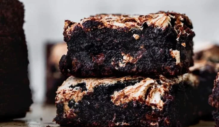 Delicious marshmallow brownies drizzled with chocolate and topped with fluffy marshmallows