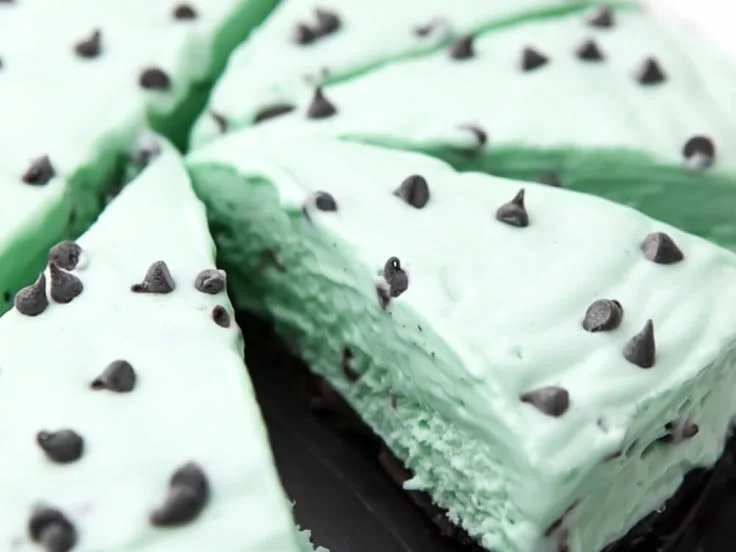 Slice of no-bake mint chocolate pie with a mint leaf garnish
