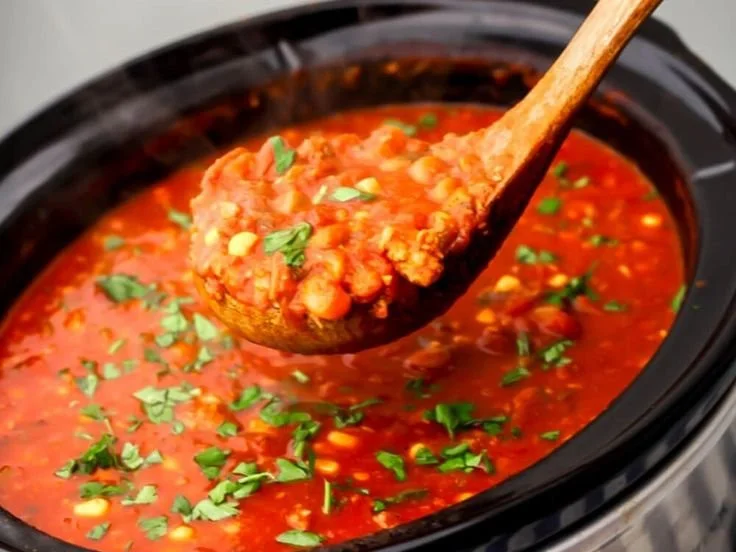 Bowl of slow cooker vegan chili topped with fresh cilantro and avocado.