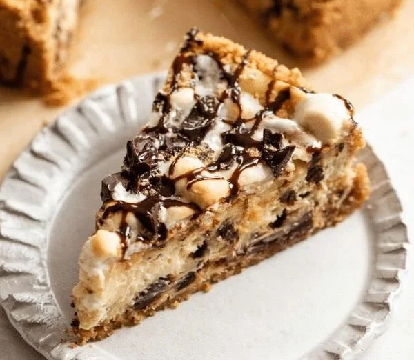 Delicious S'mores Cheesecake topped with marshmallows and chocolate drizzle