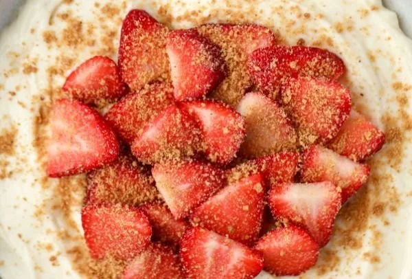 Delicious strawberry cheesecake yogurt bowl topped with fresh strawberries