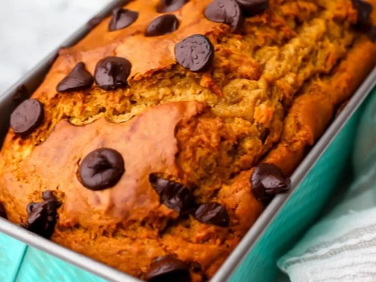 Slice of vegan banana pumpkin bread on a wooden table