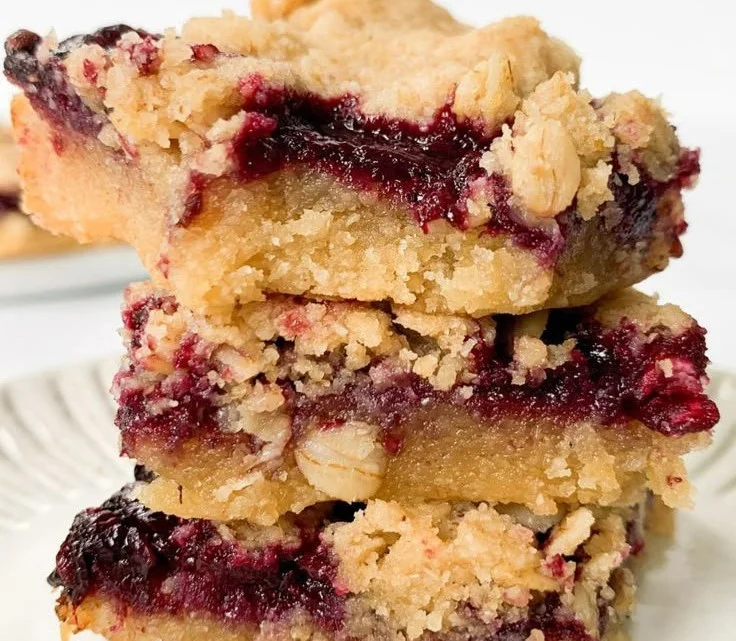 Vegan berry crumble bars filled with juicy berries and topped with a crunchy oat topping.