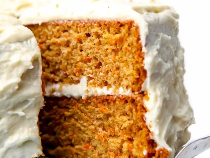 Delicious vegan carrot cake topped with cream and walnuts