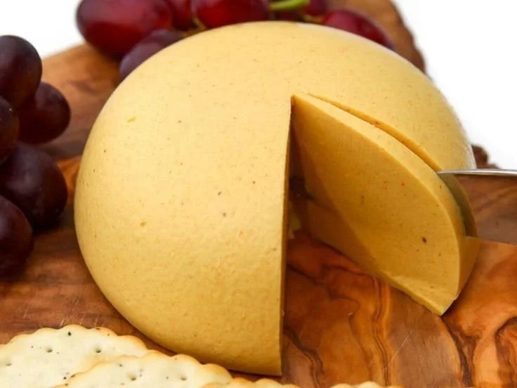 Vegan Cheddar Cheese blocks on a wooden board with herbs