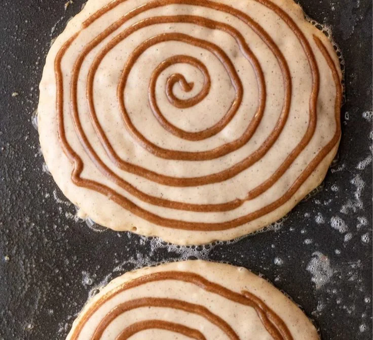 Plate of vegan cinnamon roll pancakes stacked with icing