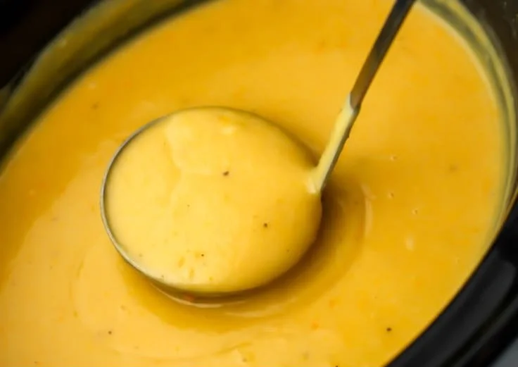 Vegan slow cooker potato soup served in a bowl with fresh herbs on top