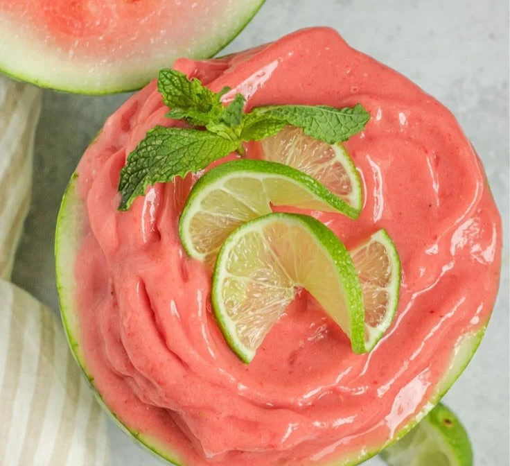 Homemade watermelon smoothie in a glass with mint garnish.